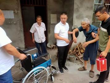 说明: 河边镇退役军人服务站站长陈永给四方村陈长宣送轮椅和纪念杯